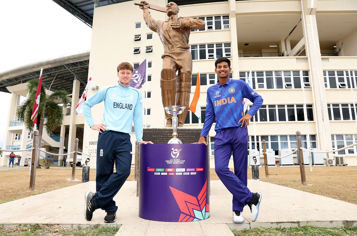 Tom Prest and Yash Dhull pose with the U19 World Cup in front of the stature of Viv Richards