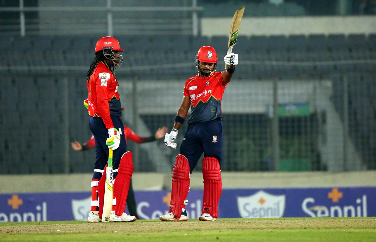 Shykat Ali raises his bat after bringing up a quick half-century