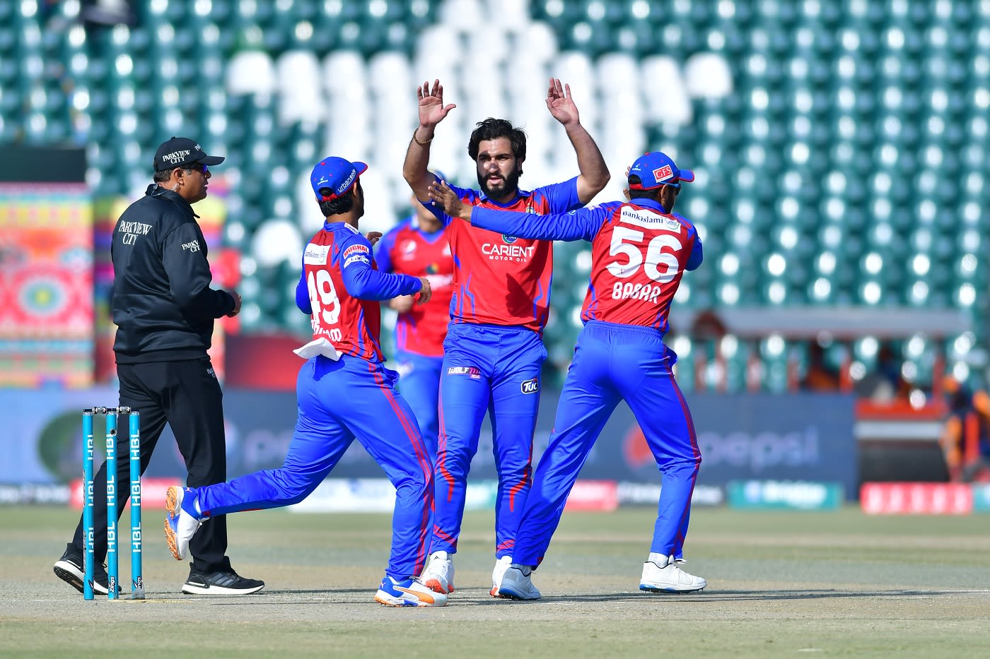Usman Shinwari is mobbed by team-mates after picking up a wicket