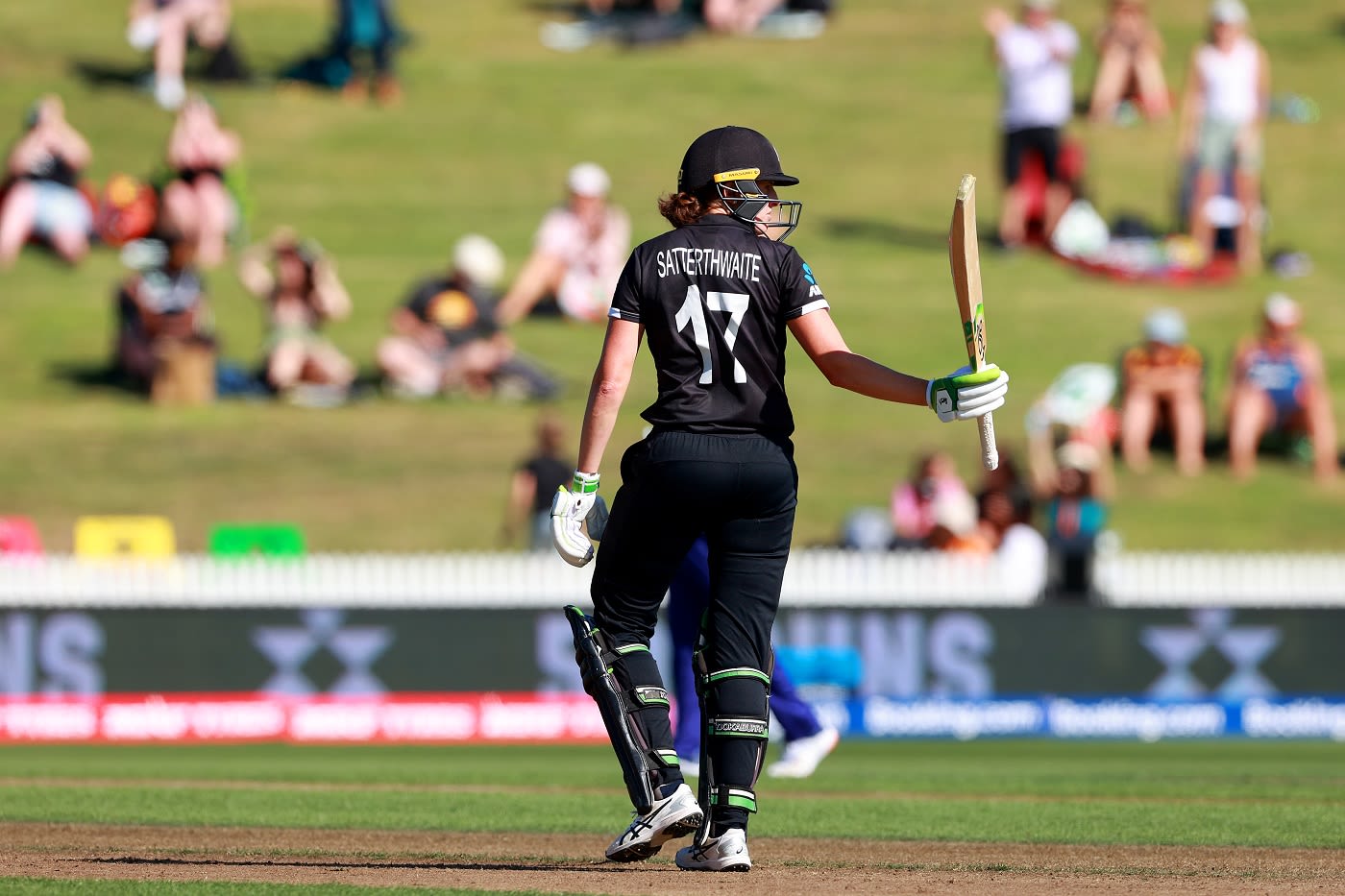 Amy Satterthwaite raises the bat after her half-century