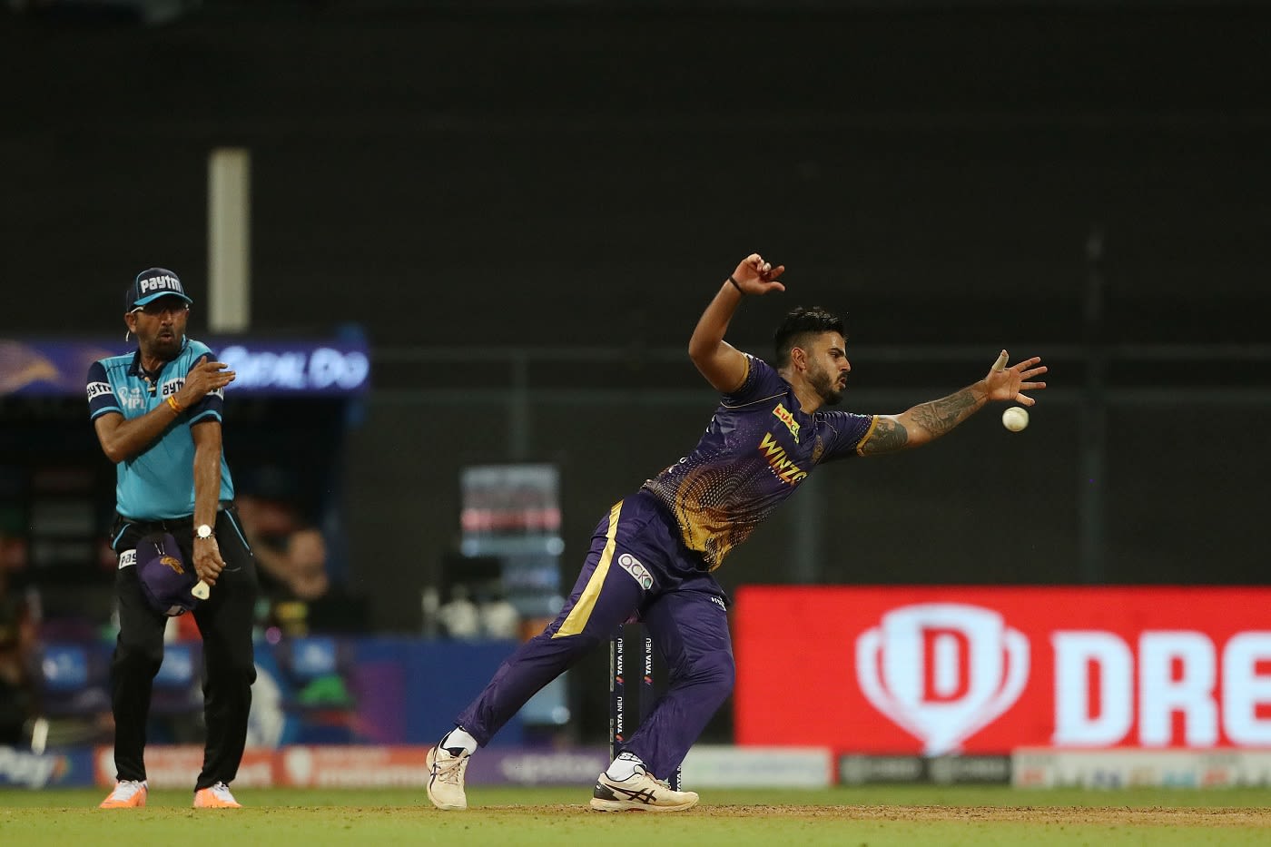 Umpire Anil Chaudhary takes evasive action while Nitish Rana dives to his left