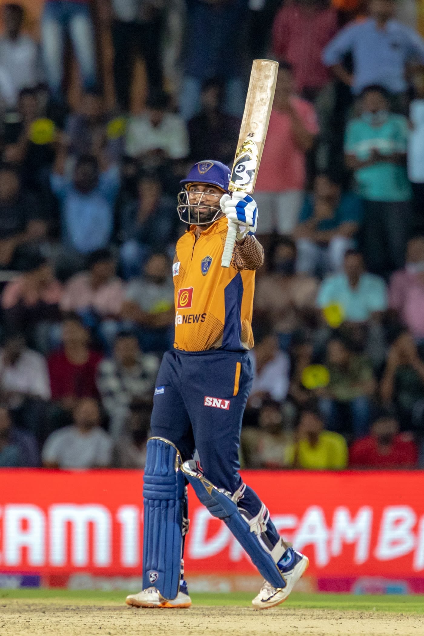 R Sanjay Yadav raises his bat after reaching a half-century