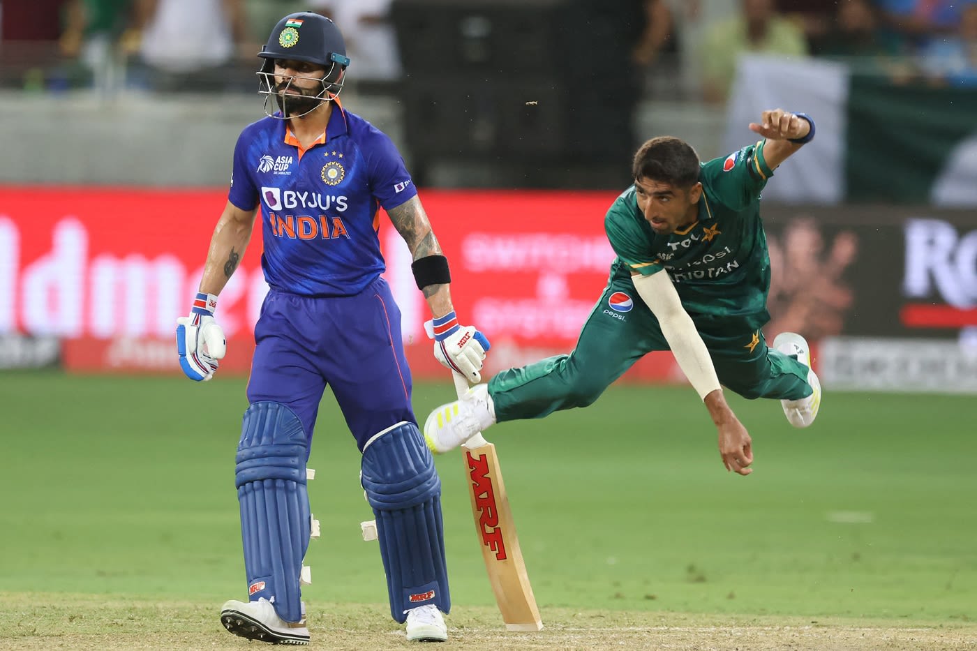 Shahnawaz Dahani bowls as Virat Kohli looks on