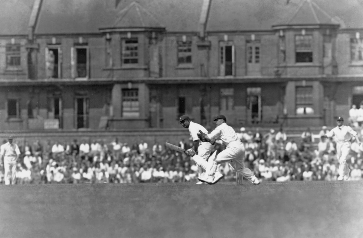 Wicketkeeper Edward Brooks looks on as the Maharajkumar of Vizianagram (right) plays a shot