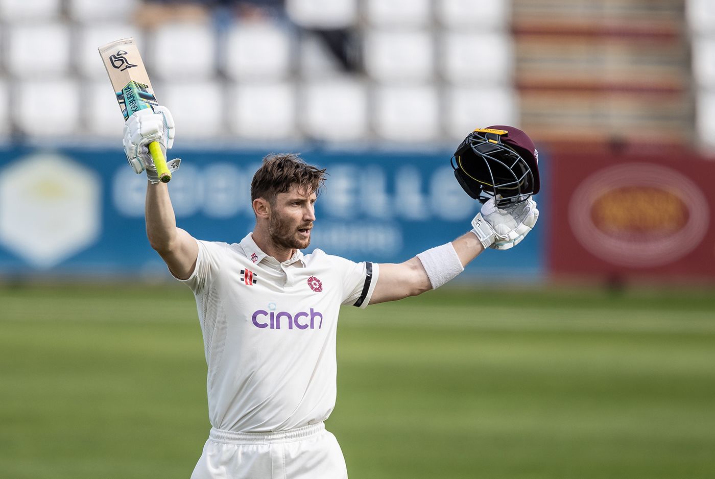 Rob Keogh raises his bat on reaching a century