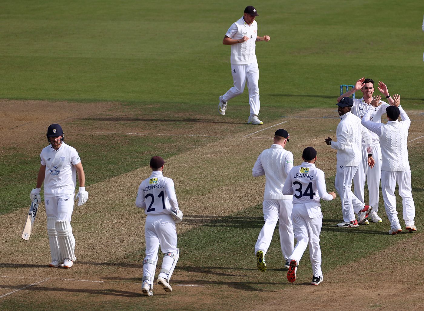 Nathan Gilchrist celebrates with team-mates after taking the wicket of Joe Weatherley