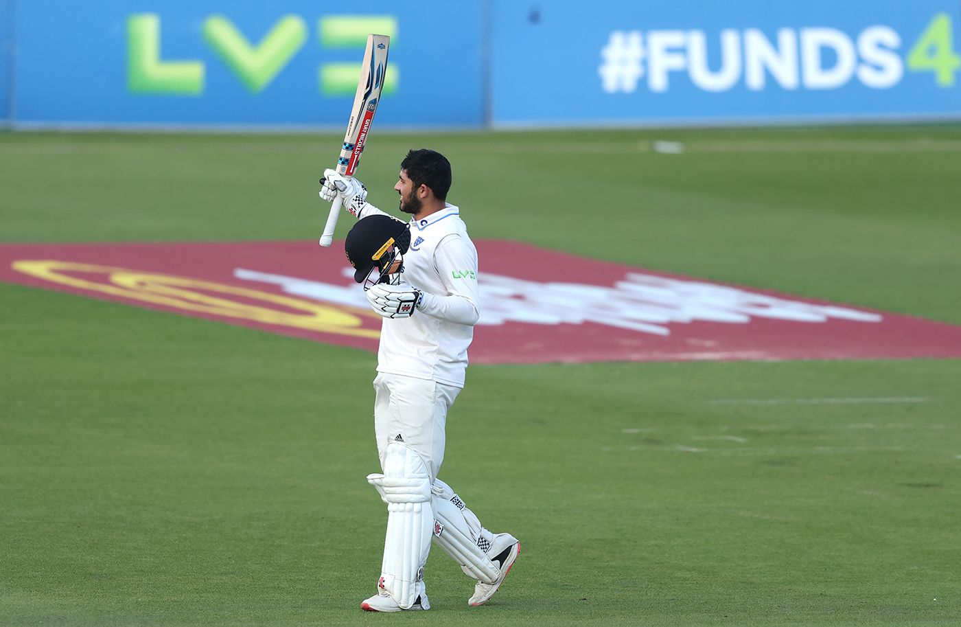 Dan Ibrahim raises his bat on reaching a maiden hundred
