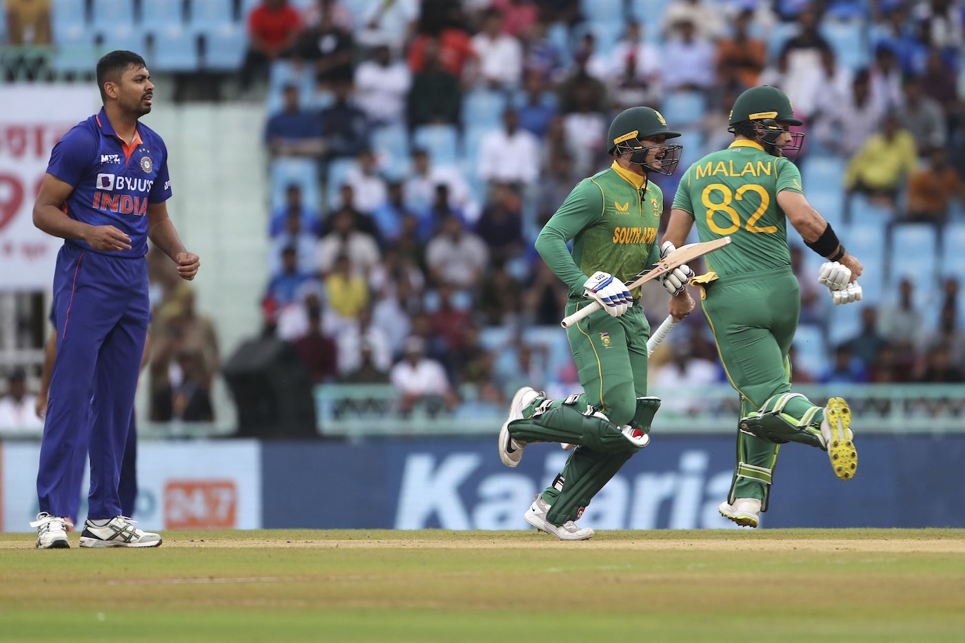 Quinton de Kock and Janneman Malan take a run while Avesh Khan watches on