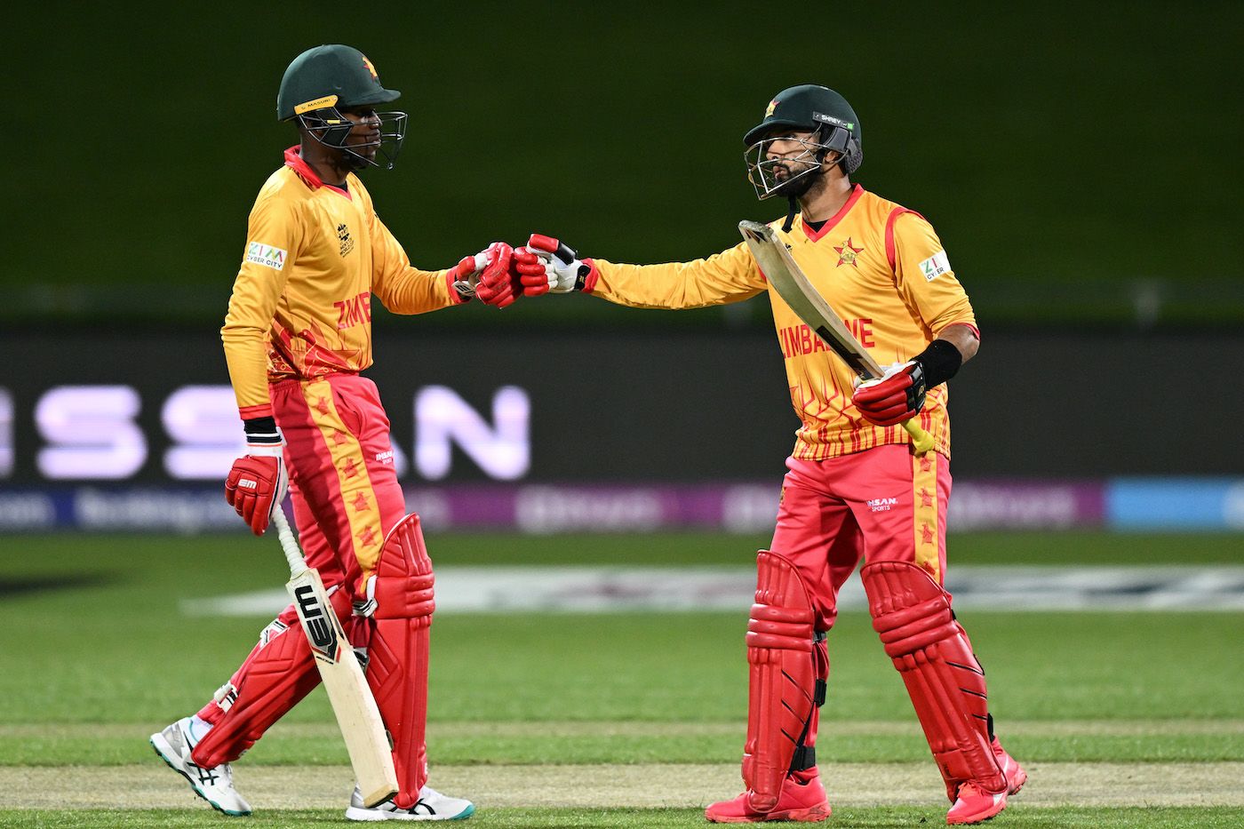 Sikandar Raza is congratulated by Milton Shumba upon completing a half-century