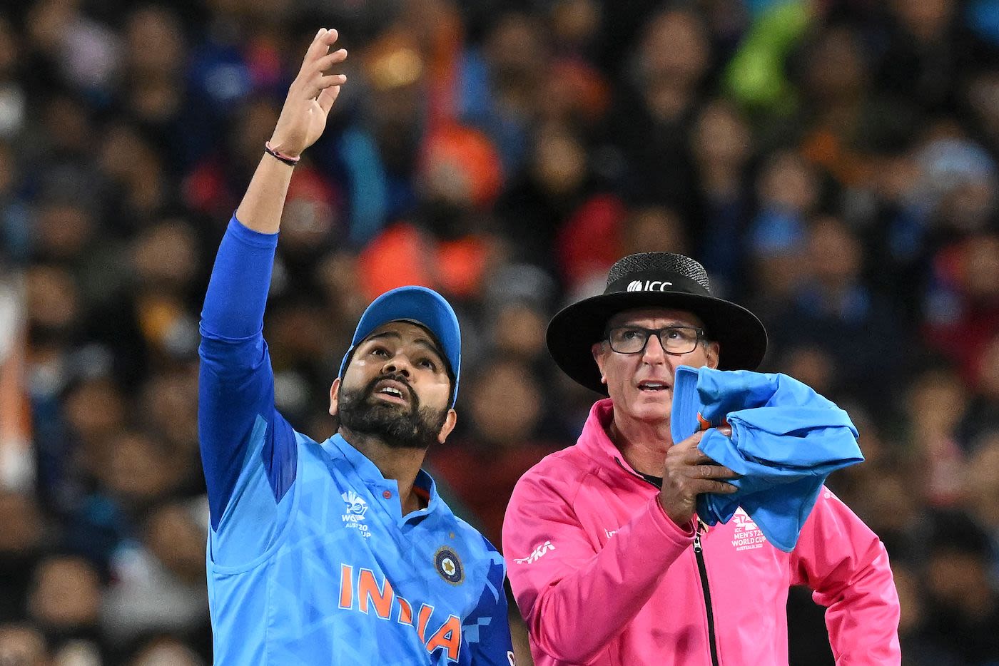 Rohit Sharma talks to umpire Rod Ticker after a lofted shot evaded the fielder because the ball hit a spider-cam cable