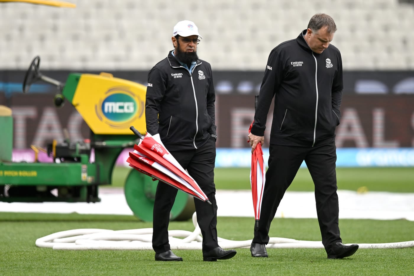 Umpires Aleem Dar and Adrian Holdstock inspect the MCG outfield