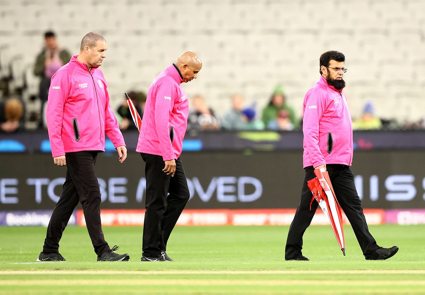 Chris Brown, Joel Wilson and Aleem Dar inspect the outfield after heavy rain