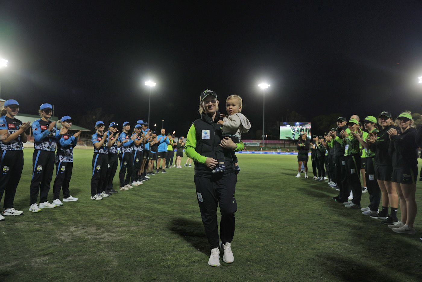 Rachael Haynes walks back with her son, Hugo, as she receives a guard of honour
