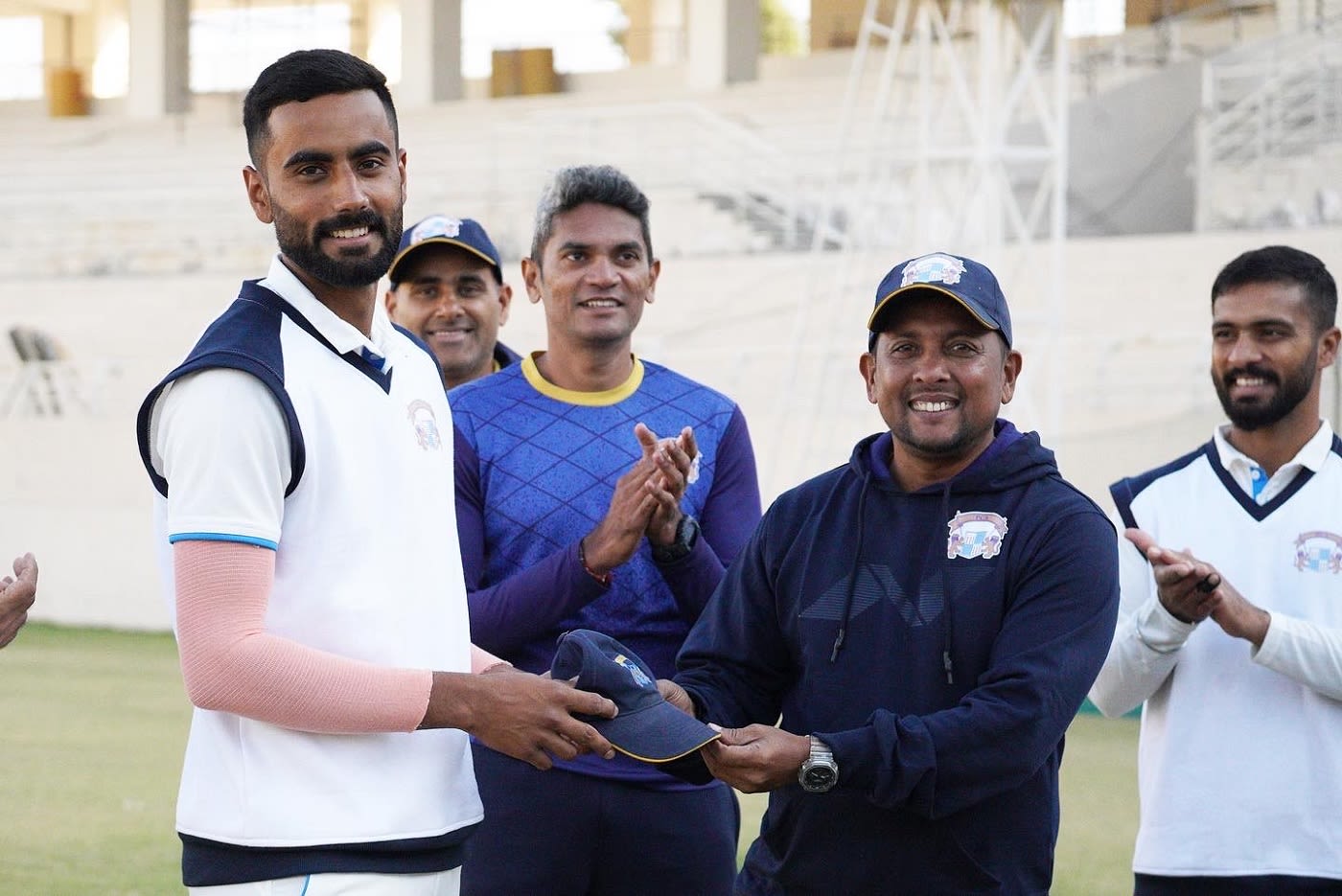 Batting coach Shiv Sunder Das presents Naman Dhir with his first-class cap