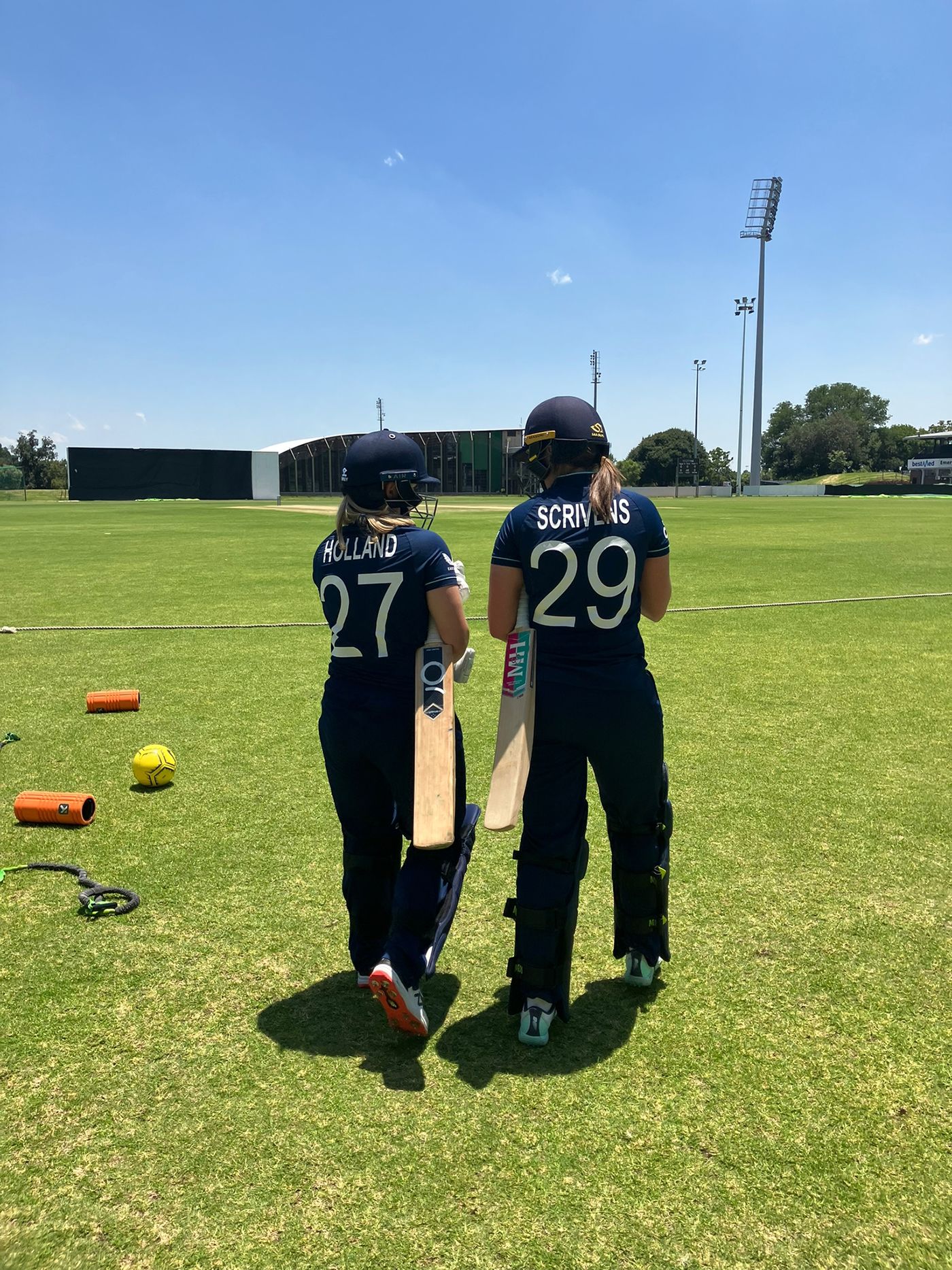 Niamh Holland and Grace Scrivens walk out to bat in a warm-up match against Indonesia