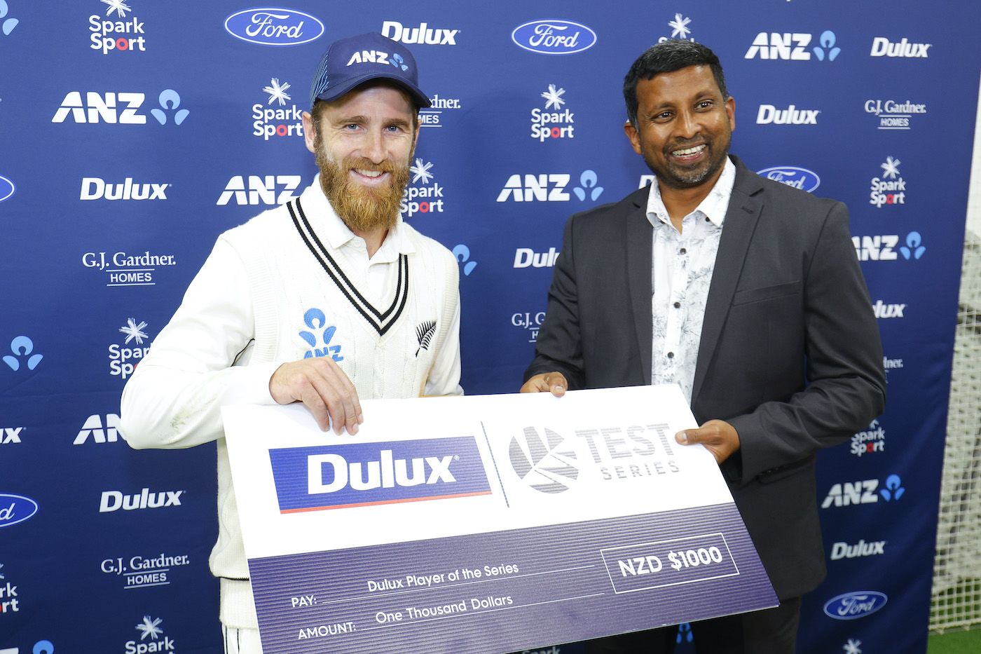 Kane Williamson receives his Player-Of-The-Series cheque from Russel Arnold