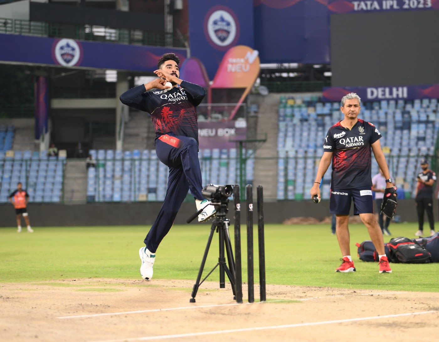 Mohammed Siraj bowls as a video camera and Sanjay Bangar have a look