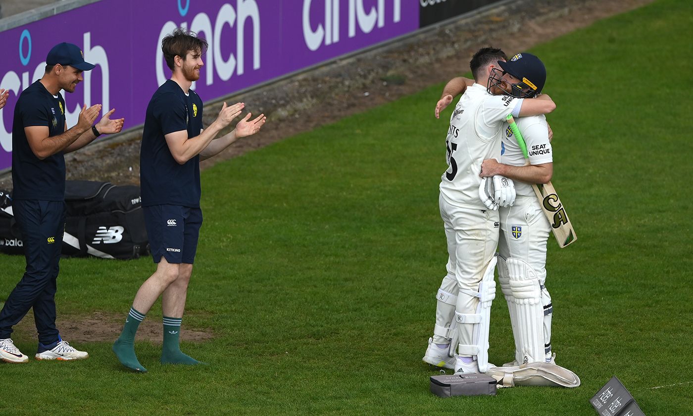 Ben Raine gets a hug from Matt Potts after guiding his team over the line