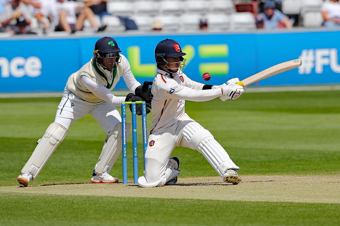Robin Das sweeps during his hundred