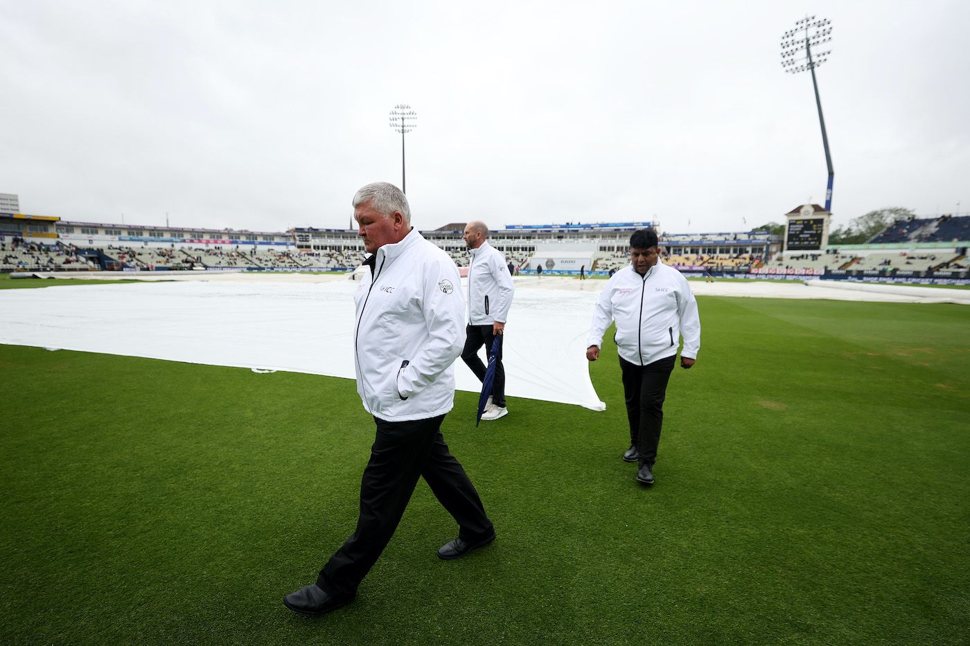 Marais Erasmus and Ahsan Raza inspect the ground after rain