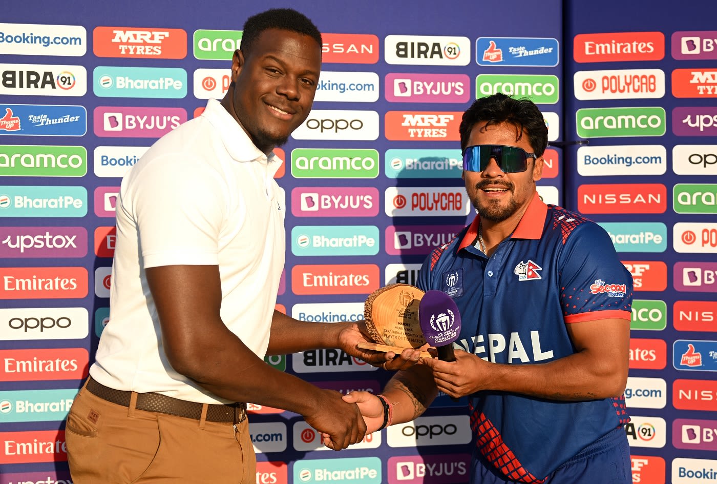 Karan KC receives the Player-of-the-Match award from Carlos Brathwaite