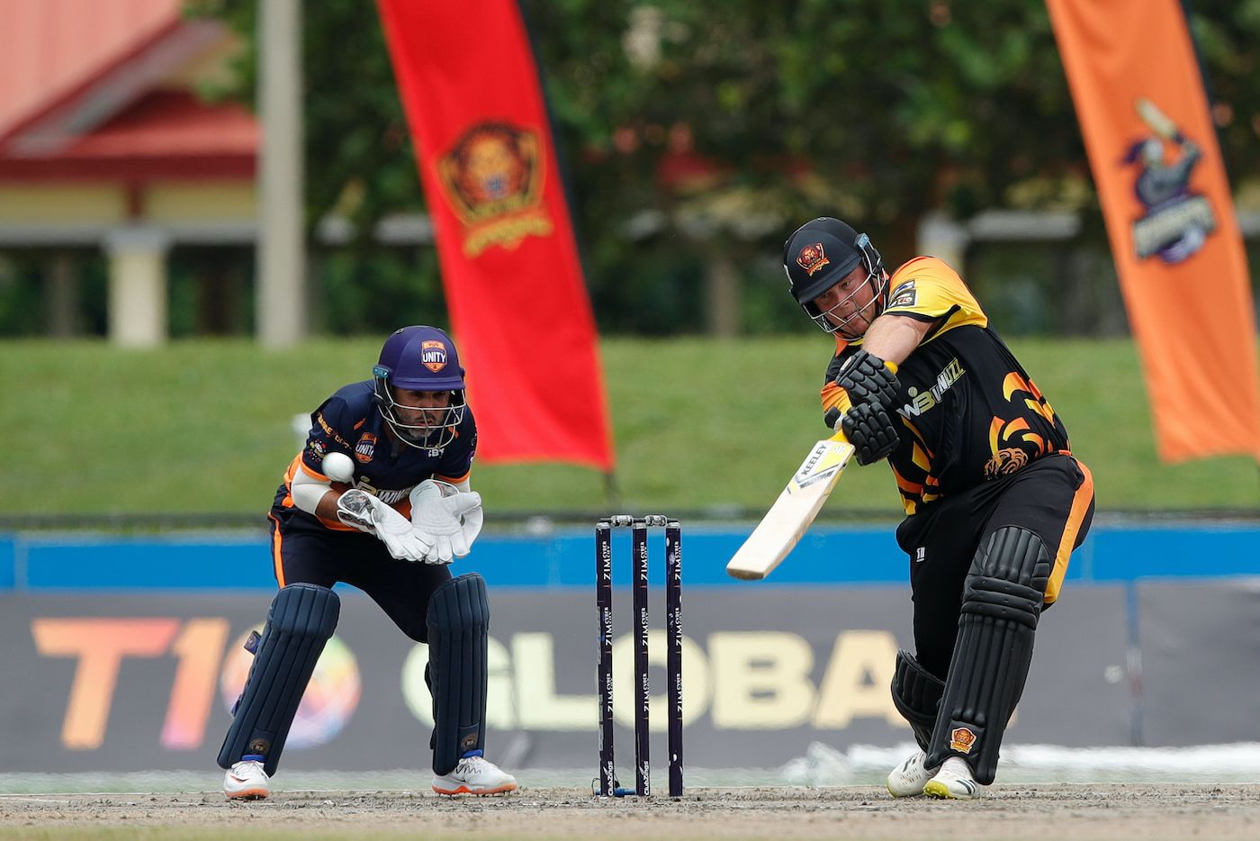 Richard Levi, who made 66, smacks the ball as Parthiv Patel watches