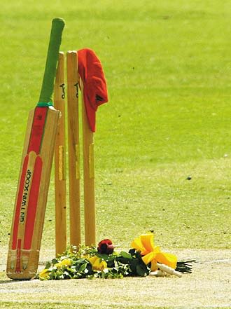 The set of stumps used in David Hookes' last game as well as a bat and red cap are arranged in tribute