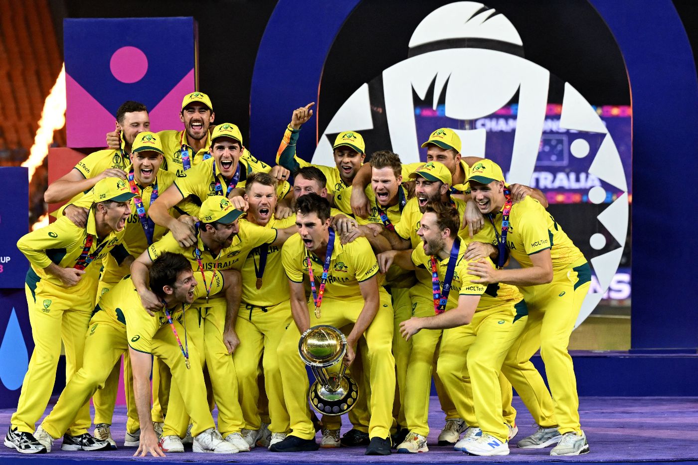 Pat Cummins prepares to lift the World Cup, as his team-mates giddily look on