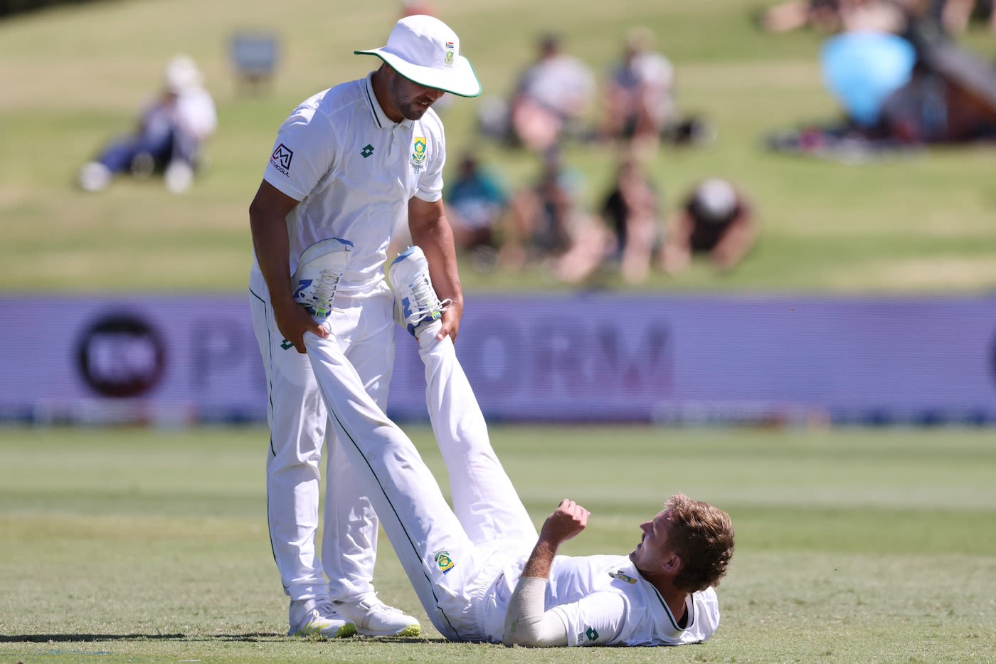 Ryan de Swardt gets his hamstrings stretched by Dane Paterson