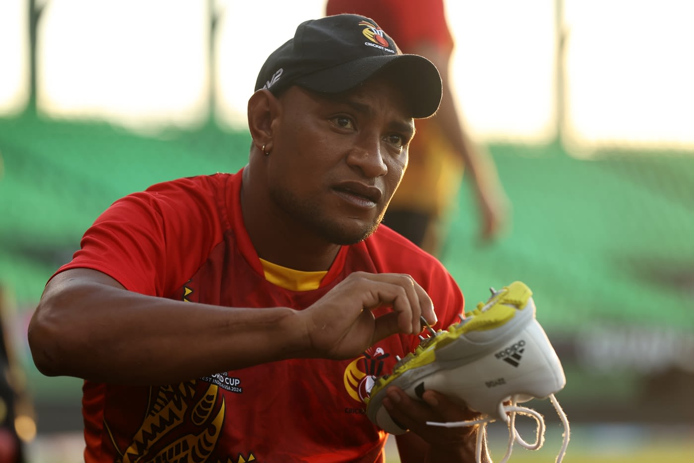 PNG's Kiplin Doriga cleans his spikes before a training session