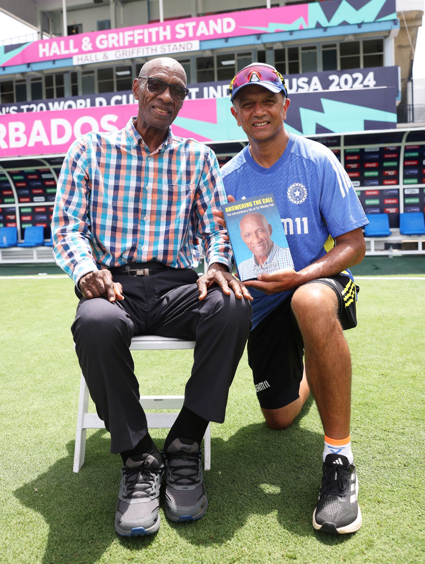 West Indies legend Wes Hall presents India head coach Rahul Dravid with his book, in front of the stand named after him at Kensington Oval