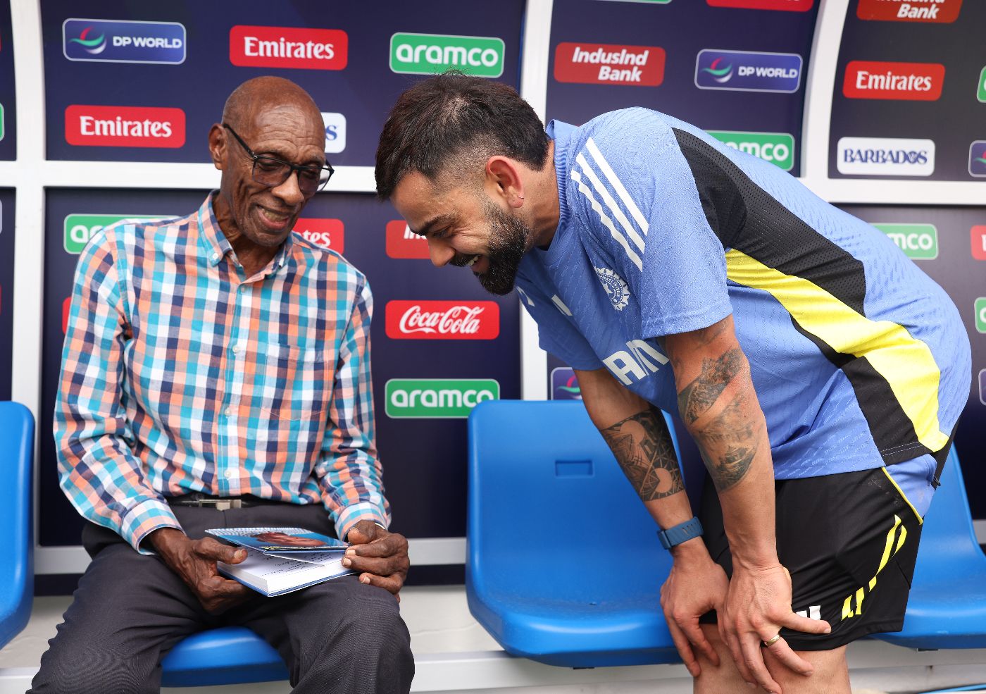 Wes Hall has a chat with Virat Kohli while presenting him with his book