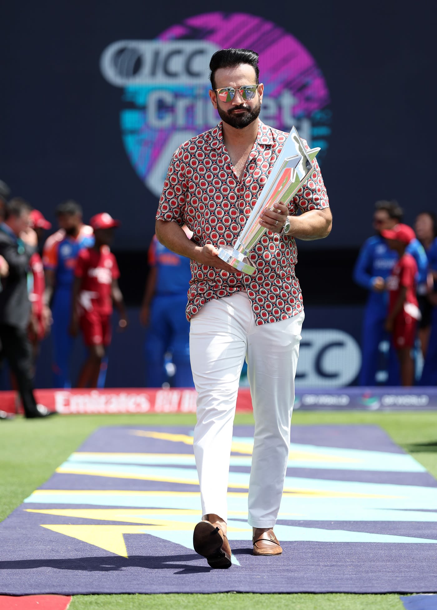 Former India allrounder Irfan Pathan carries the T20 World Cup trophy to the field of play