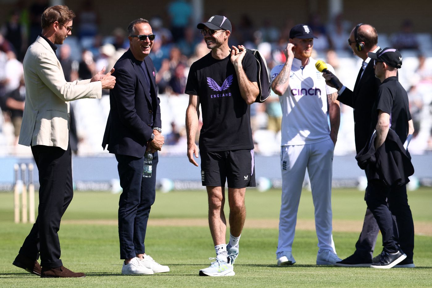 James Anderson and Stuart Broad chat in their non-playing capacity as Ben Stokes talks at the toss