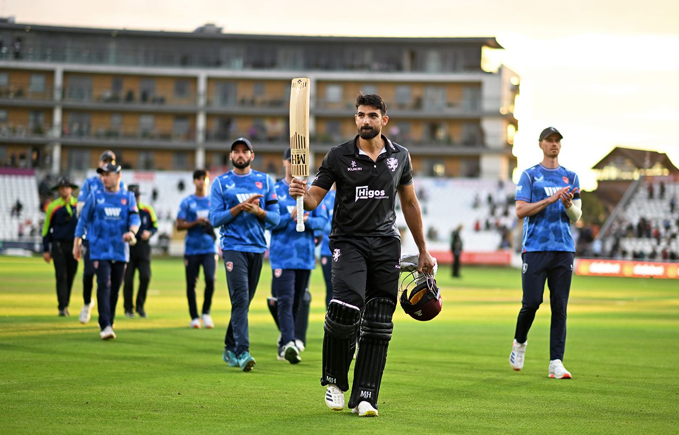 Andrew Umeed leads the players off after his unbeaten 114 secured victory