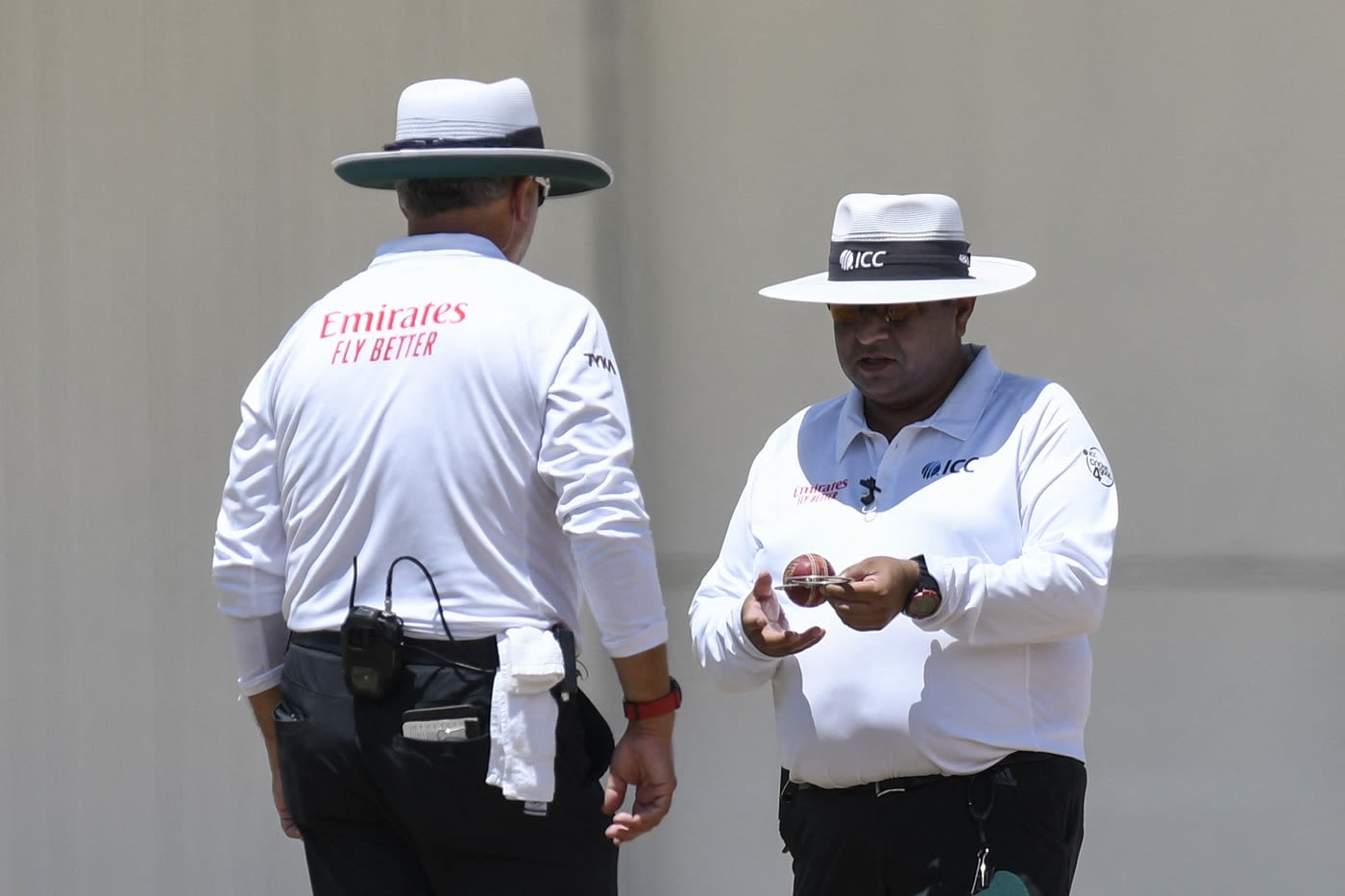 Umpire Ahsan Raza inspects the ball
