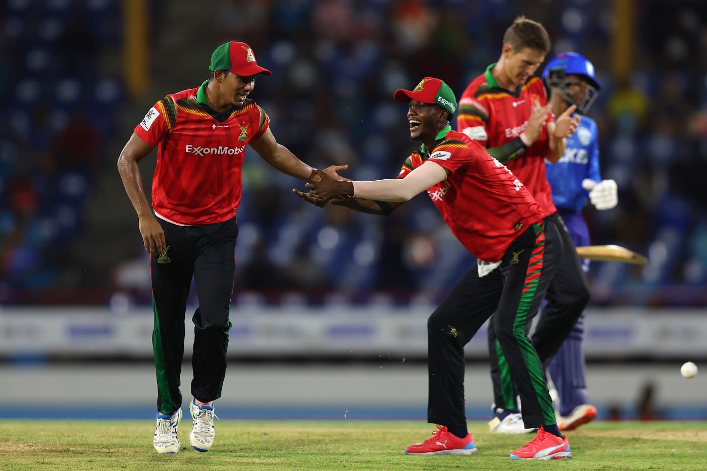 Gudakesh Motie and Junior Sinclair celebrate a run out