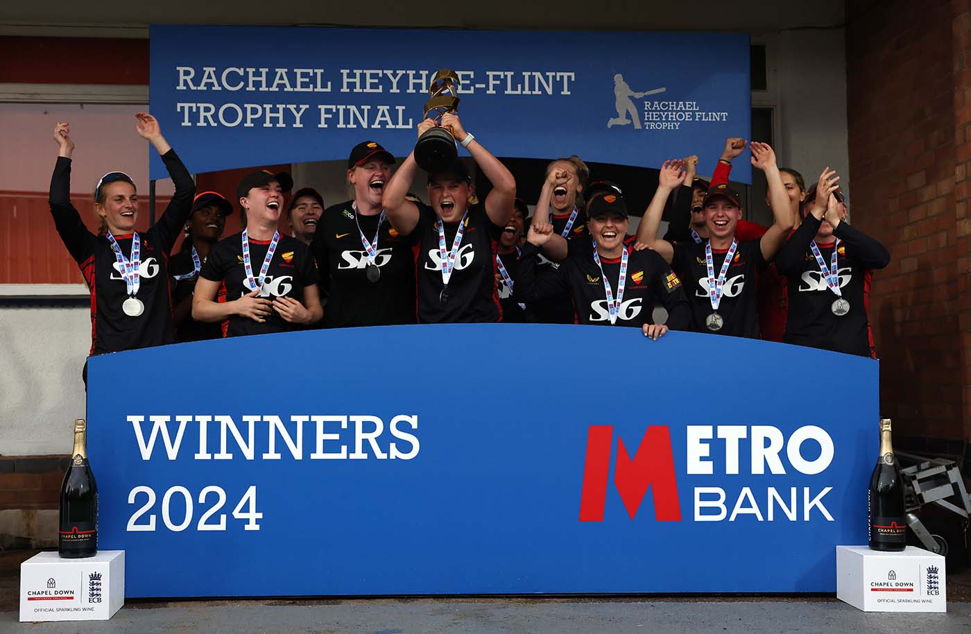 Grace Scrivens holds the Rachael Heyhoe Flint Trophy aloft