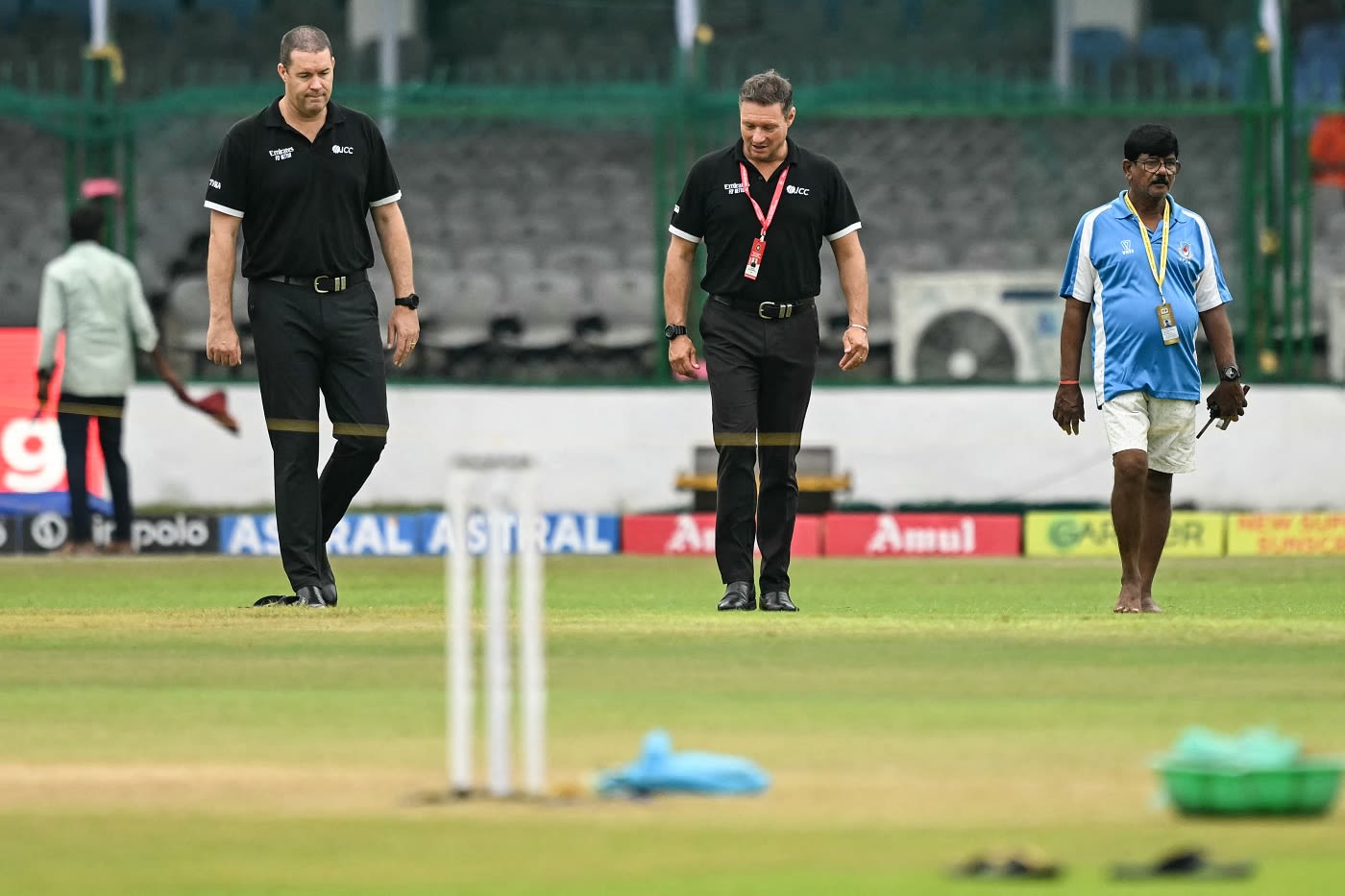 Umpires Chris Brown and Richard Kettleborough examine a few wet spots on the outfield
