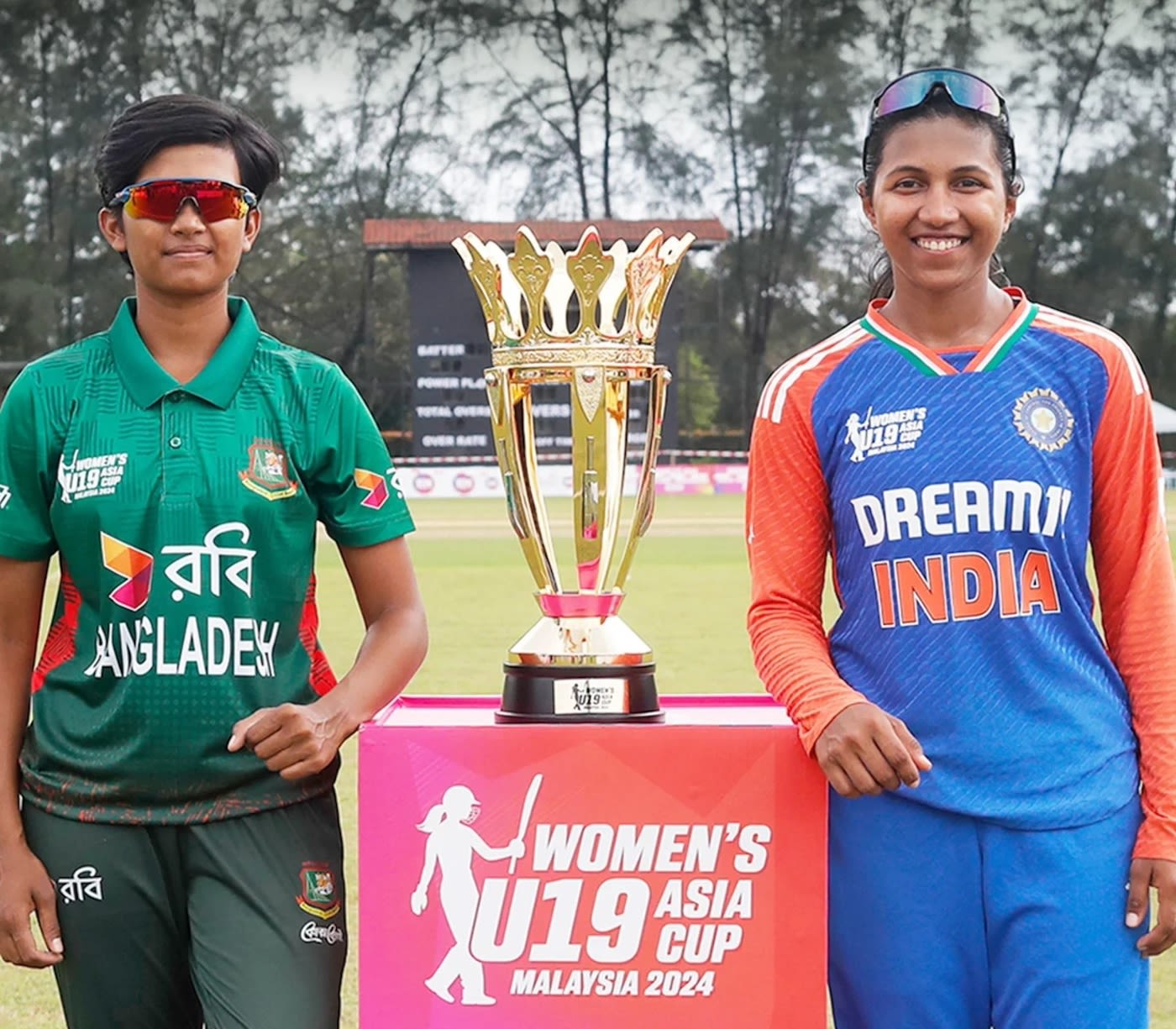 Sumaiya Akter and Niki Prasad, the two captains, pose with the trophy