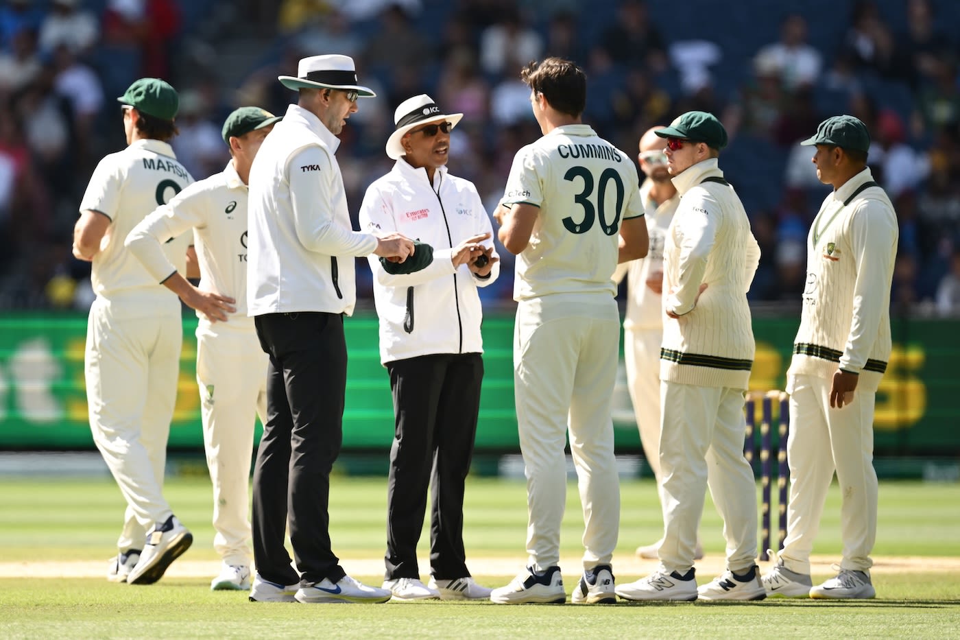 Pat Cummins speaks to umpires Michael Gough and Joel Wilson after a decision went against Australia