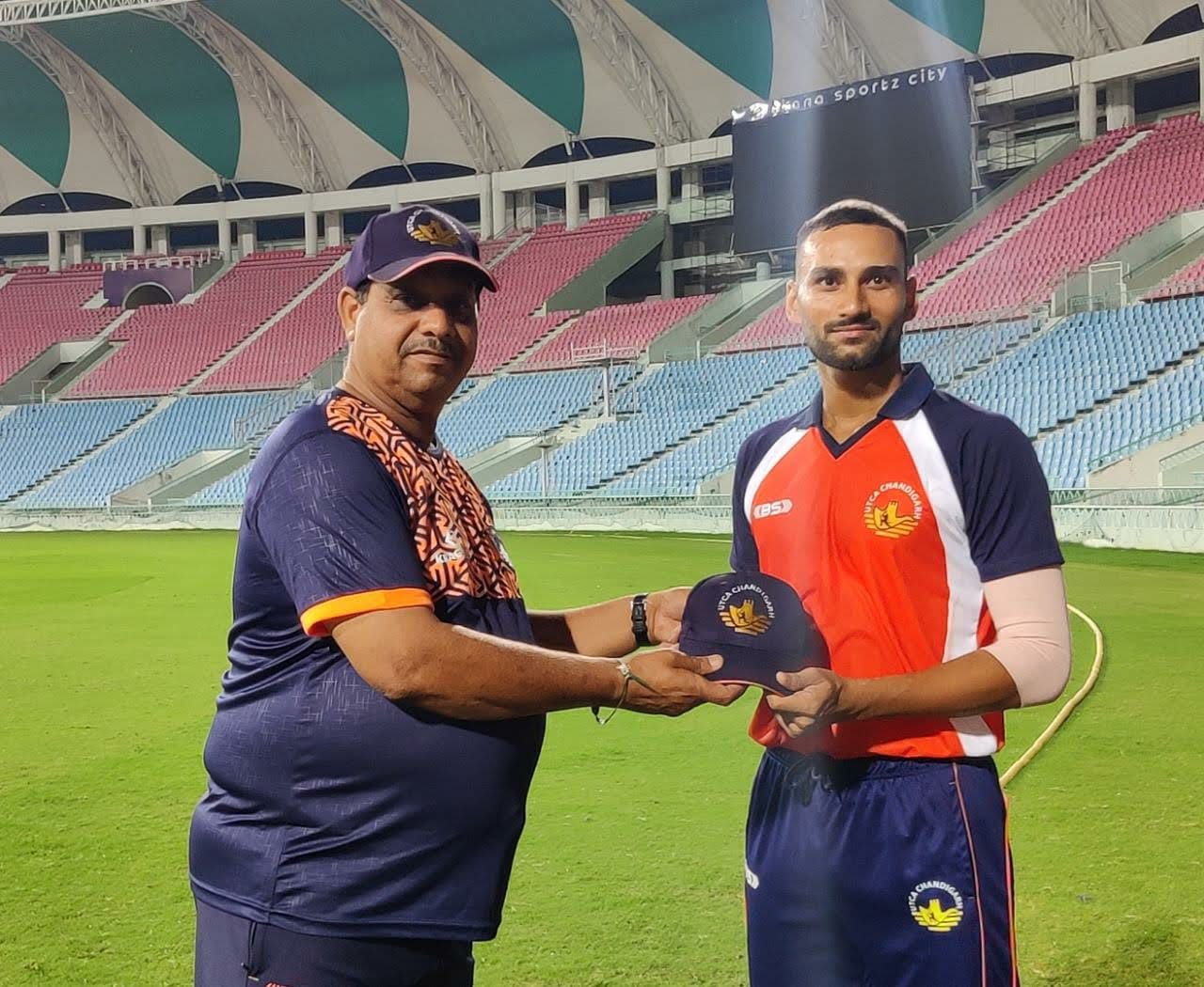 Chandigarh head coach Sunil Saggi presents Rohit Dhanda his T20 cap