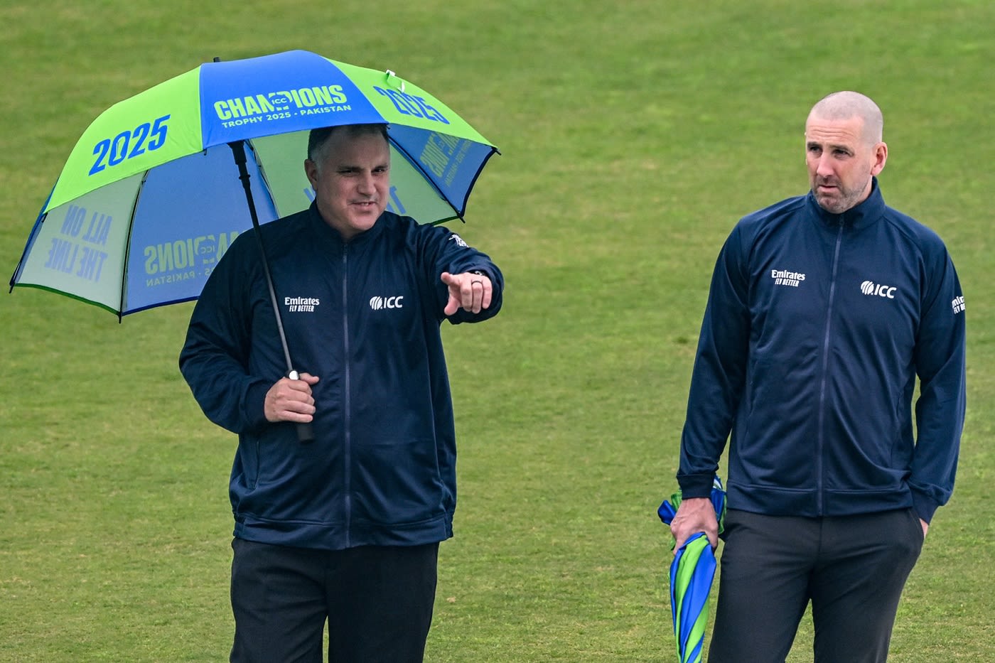 Umpires Adrian Holdstock and Michael Gough inspect the outfield after rain