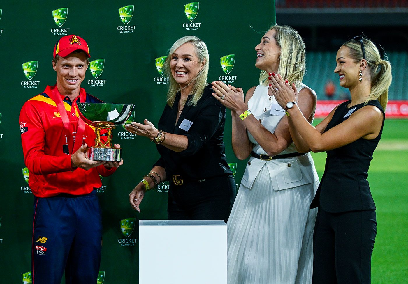 Jane Jones, Phoebe Jones and Augusta Jones present Nathan McSweeney with the Dean Jones Trophy