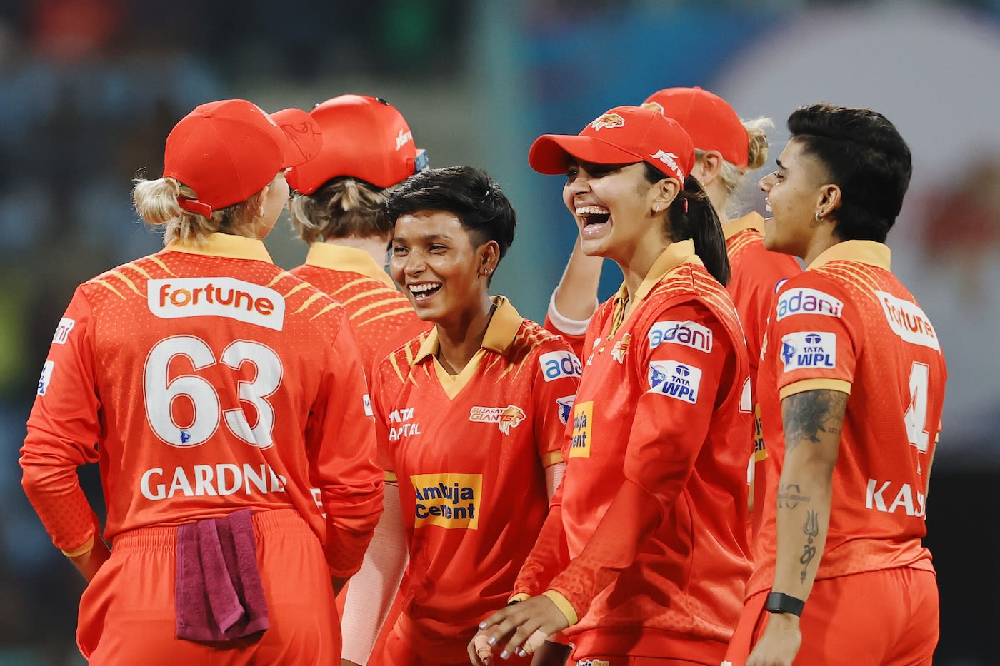 The Gujarat Giants players gather around Priya Mishra and Harleen Deol after a wicket