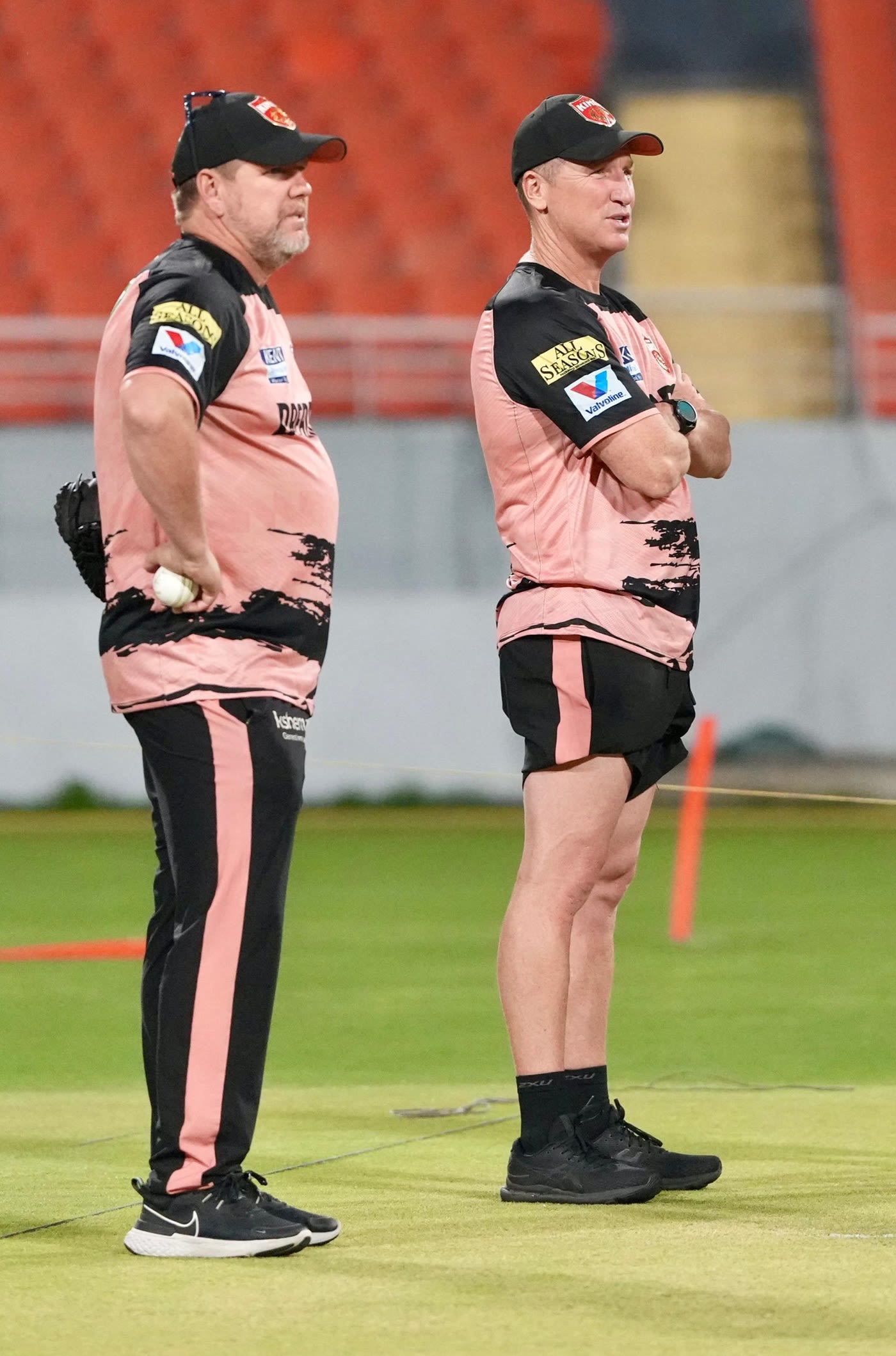 Coaches James Hopes and Brad Haddin watch training