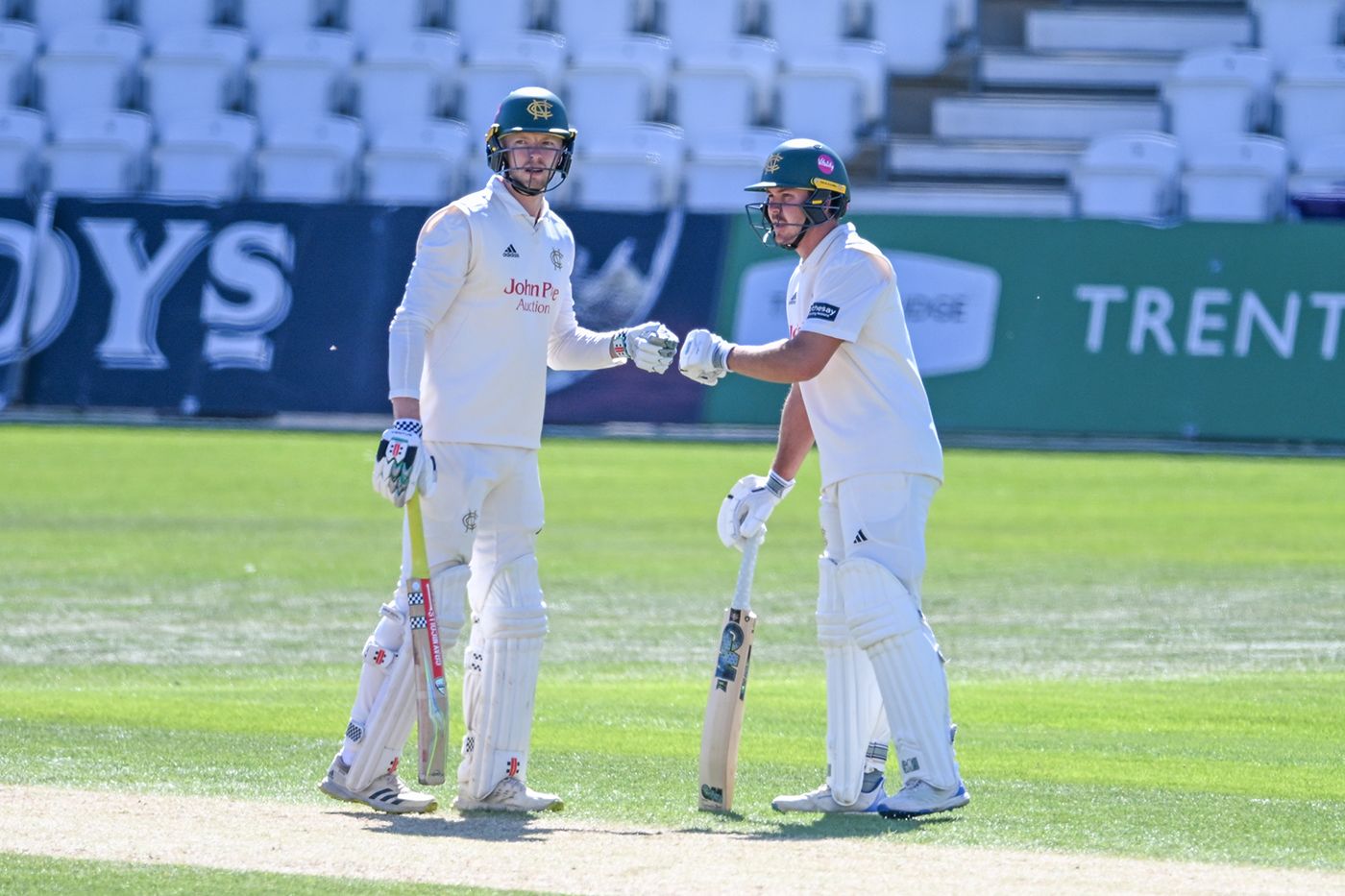 Lyndon James touches gloves with Matt Montgomery during their 118-run partnership for the seventh wicket