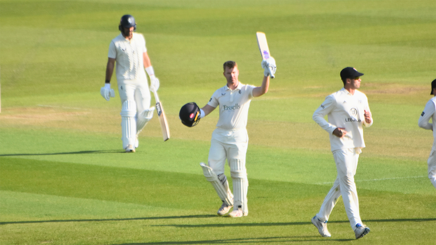 Ben Compton raises his bat on reaching a century