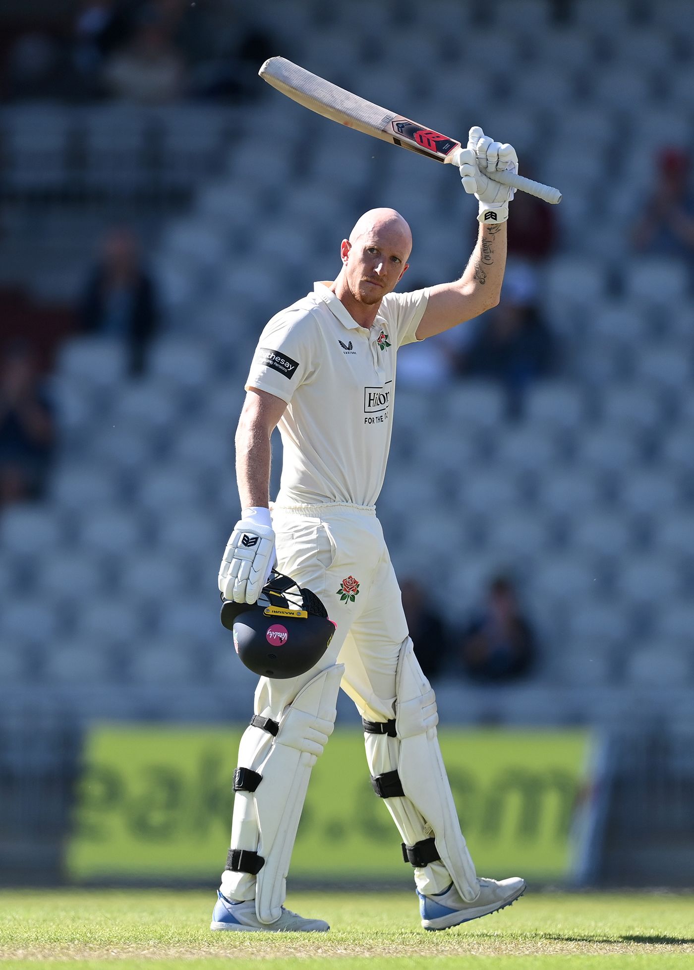 Luke Wells raises his bat on reaching three figures