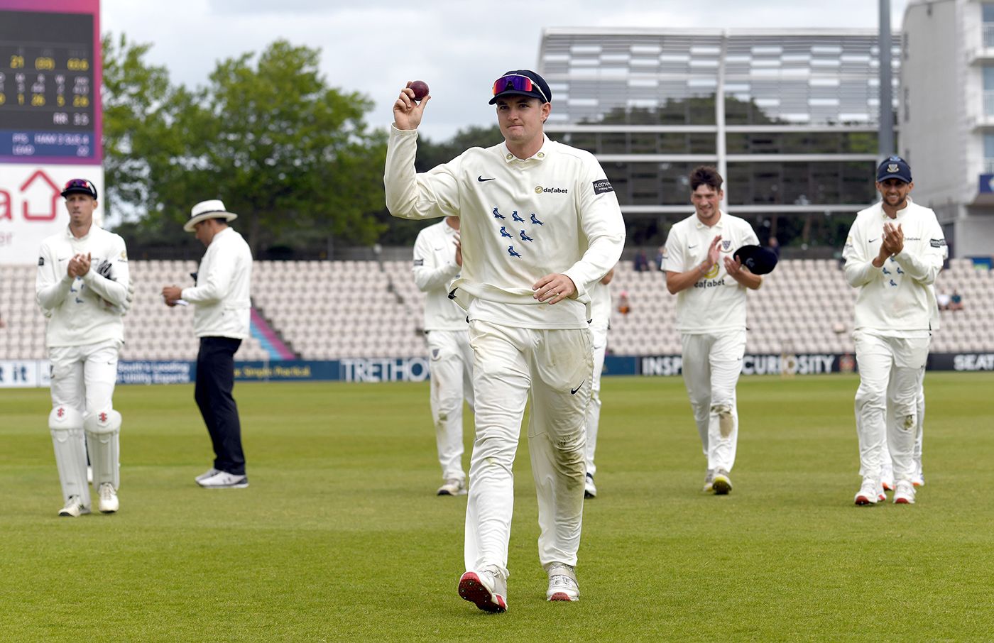 Jack Carson walks off with the match ball after taking 5 for 26